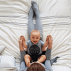 Baby wearing 'Hug Life' tee on mama's lap